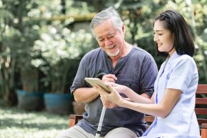 nurse reading to elderly male patient