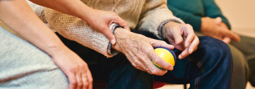 elderly person's hand holding a ball