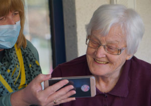 older woman being shown a cell phone