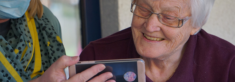 older woman being shown a cell phone