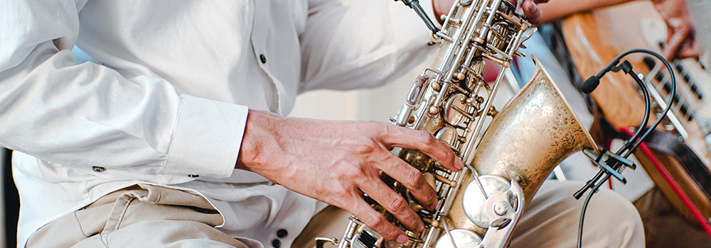 a close up of a man playing a saxophone outside
